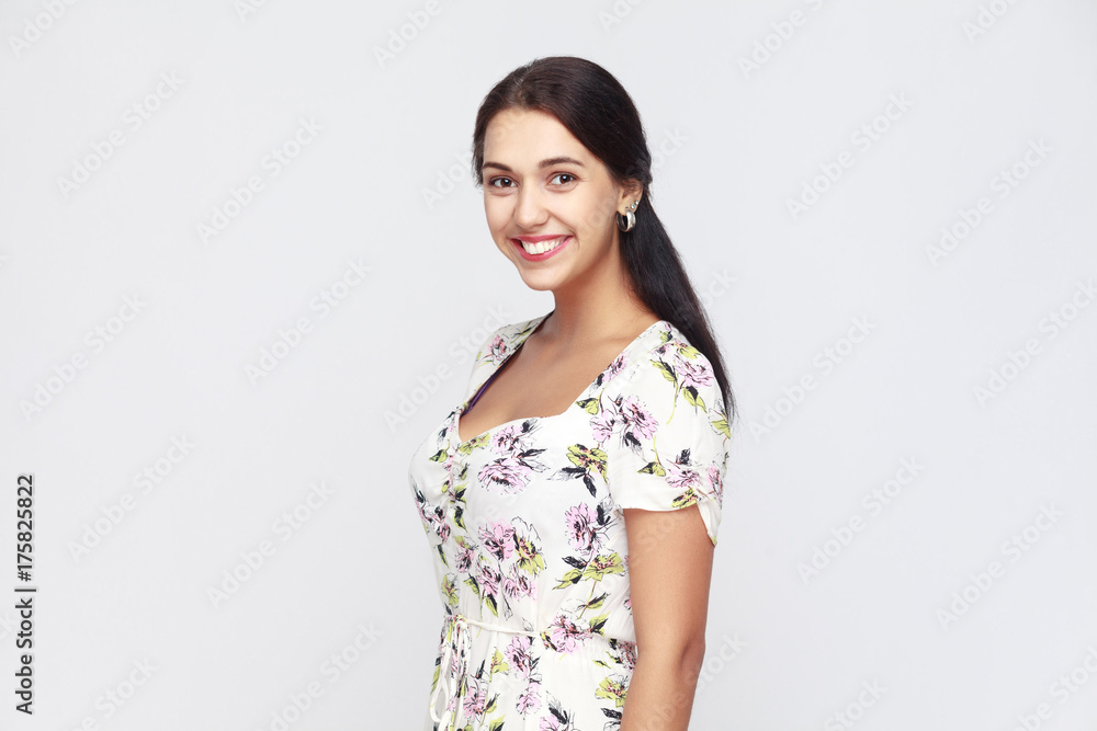 Portrait of happiness woman in flowers dress, looking at camera and toothy smile. Portrait of happiness woman in flowers dress, looking at camera and toothy smile.