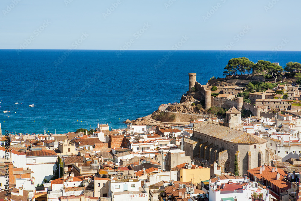 Top view of the town and castlein Tossa de mar, city on the Costa Brava. Buildings and hotels by the beach. Amazing city in Girona, sea and moored boats in Catalonia. City and see.