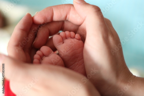 baby's legs and father's hands