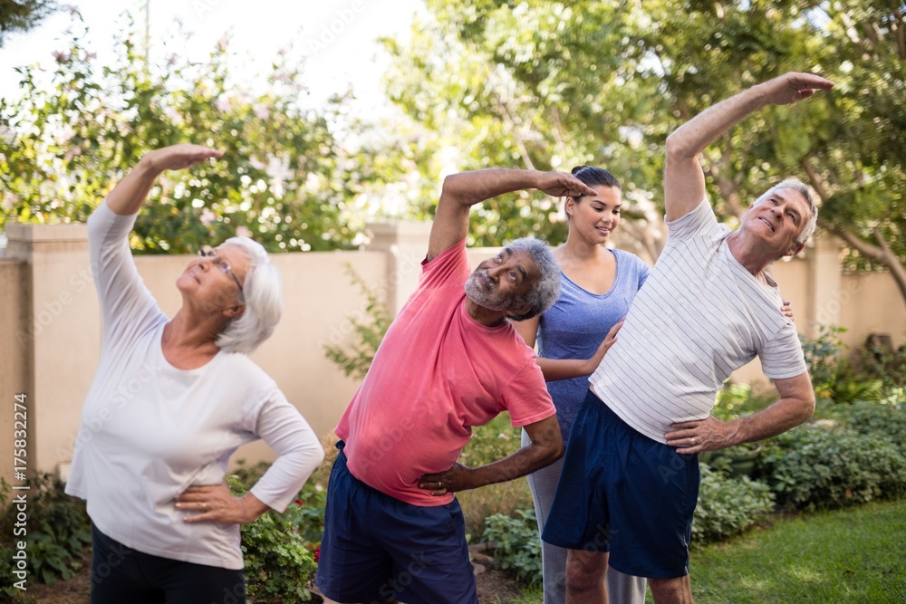 Female trainer guiding senior people while exercising Female trainer guiding senior people while exercising
