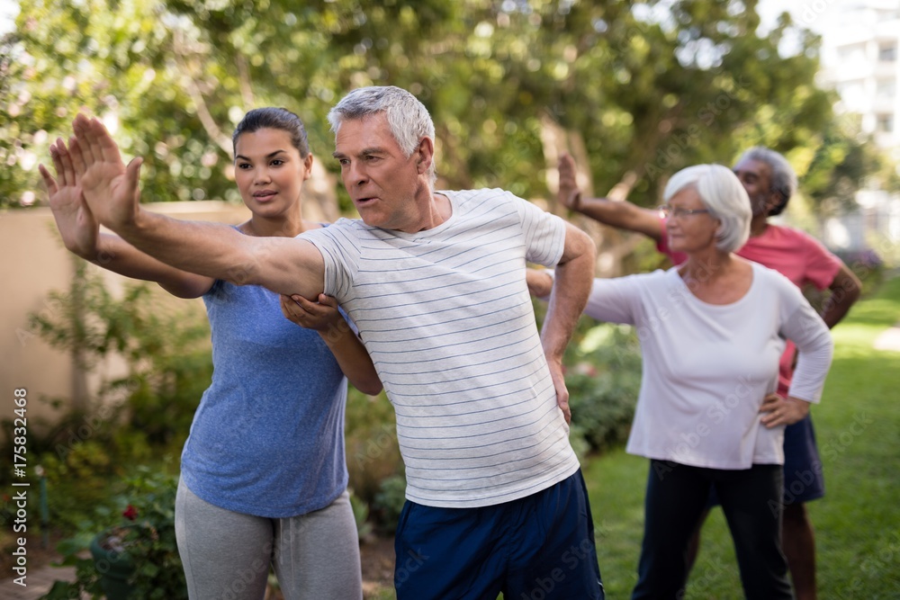 Trainer showing stretching exercise to senior people Trainer showing stretching exercise to senior people