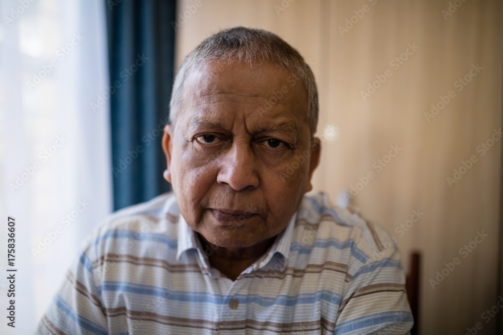 Portrait of senior man sitting by window Portrait of senior man sitting by window