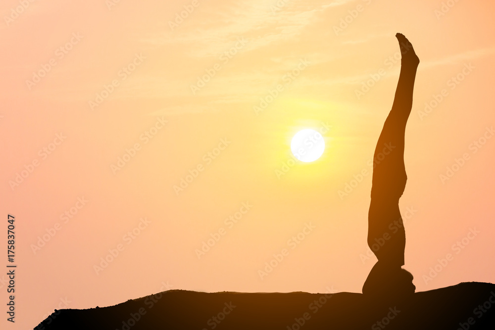 Silhouette of a beautiful Yoga woman with sun background 