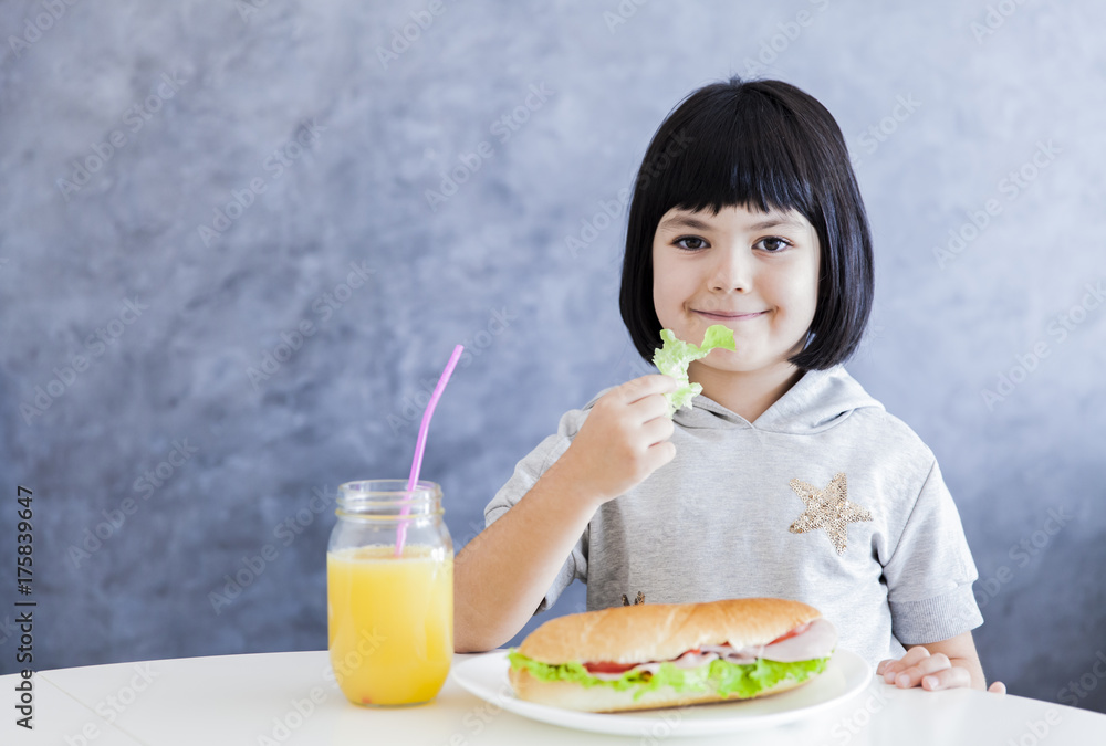 Cuttle black hair little girl having breakfast and eat lettuce Cuttle black hair little girl having breakfast and eat lettuce