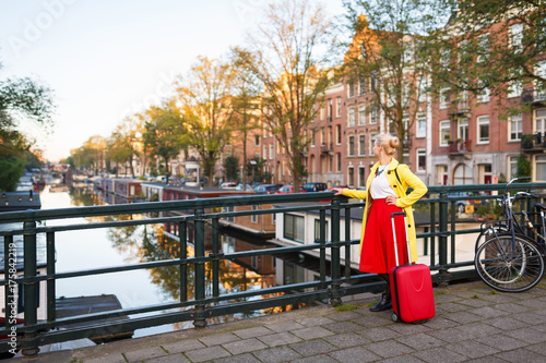 Photography The traveler with suitcase is walking in the street of Amsterdam city in autumn