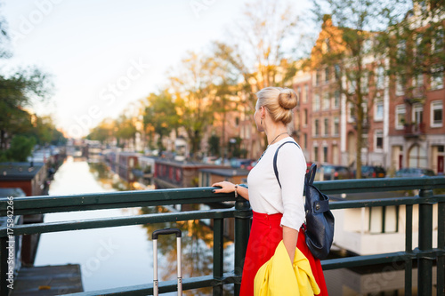 Photography The traveler with suitcase is walking in the street of Amsterdam city in autumn