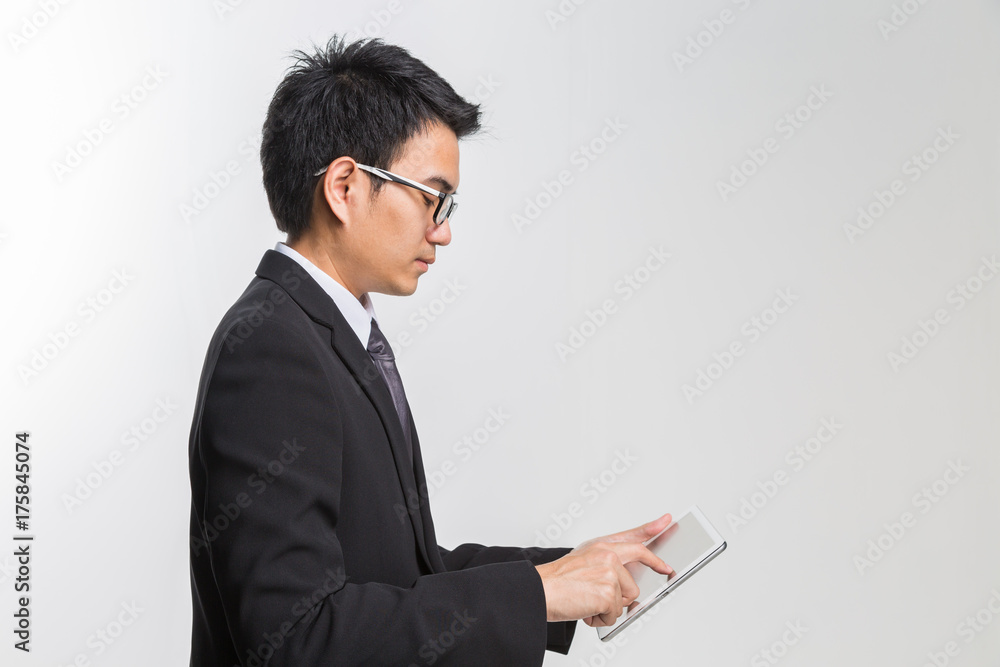 Young asian handsome businessman using his tablet on white backgrond. Young asian handsome businessman using his tablet on white backgrond.