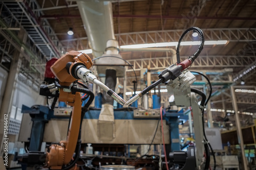 Team robots welding are standby in assembly line
