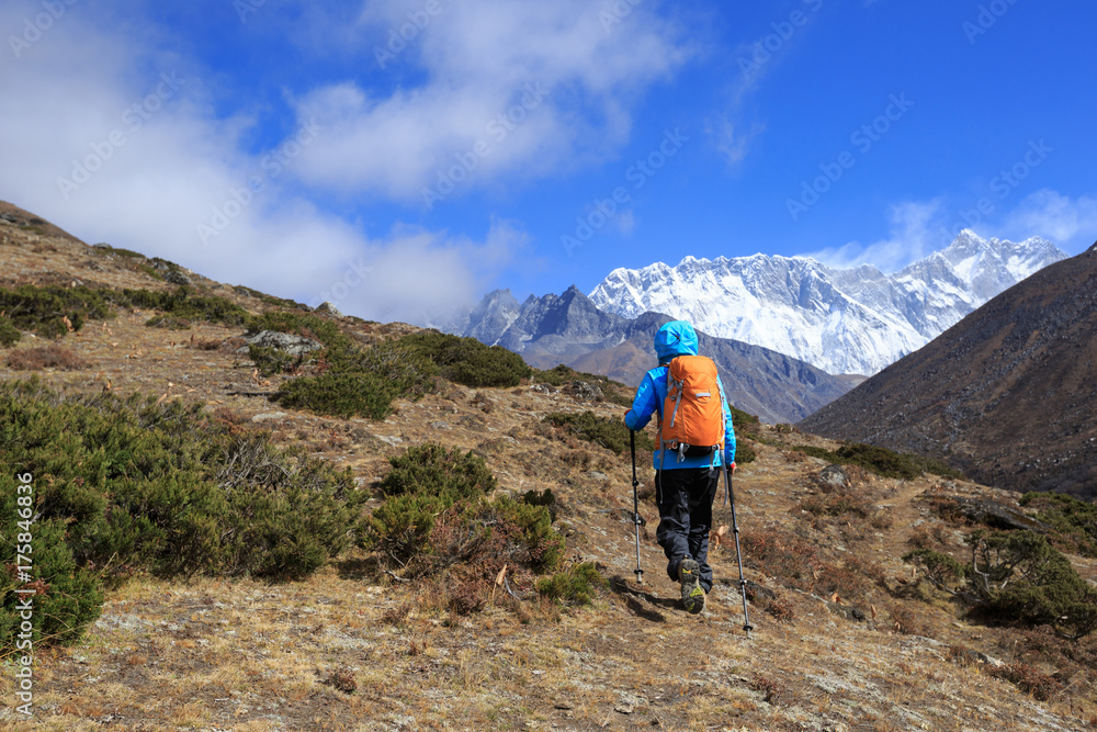 young woman backpacker trekking on himalaya mountains