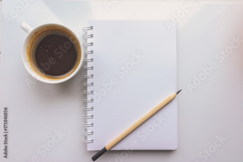 A notebook, a pencil, a Cup of coffee on a white background. Top view 