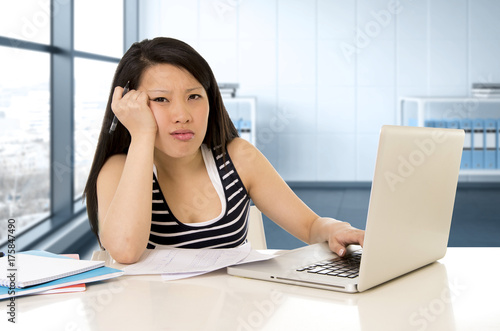 chinese asian student or business woman tired working and studying on computer laptop