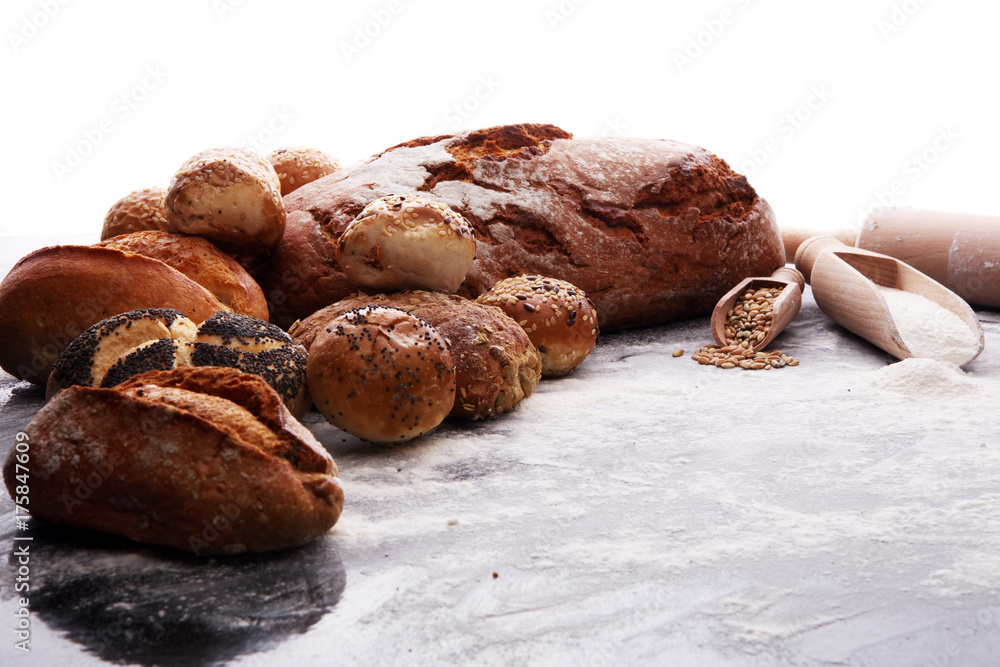 Different kinds of bread and bread rolls on black board. Kitchen or bakery poster design Different kinds of bread and bread rolls on black board. Kitchen or bakery poster design