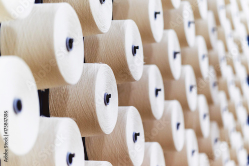 Fotografia, Obraz large group of bobbin thread cones on a warping machine in a textile mill