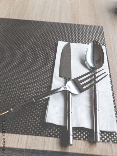 Plates and cutlery on a wooden table. Cutlery set of fork, spoon and knife in vintage theme photo