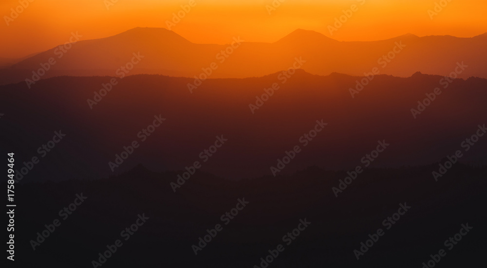 A beautiful colorful sunset in mountain ridge with glowing red haze