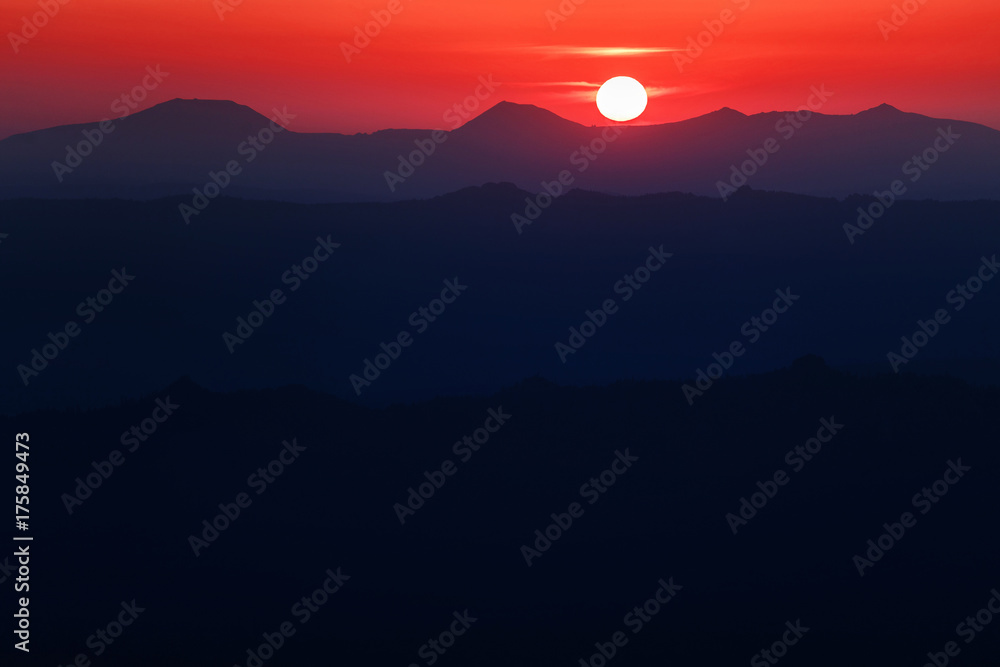 A beautiful colorful sunset in mountain ridge with glowing red haze A beautiful colorful sunset in mountain ridge with glowing red haze
