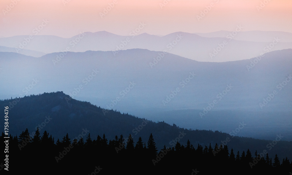 Naklejka A beautiful colorful sunset in mountain ridge with glowing red haze
