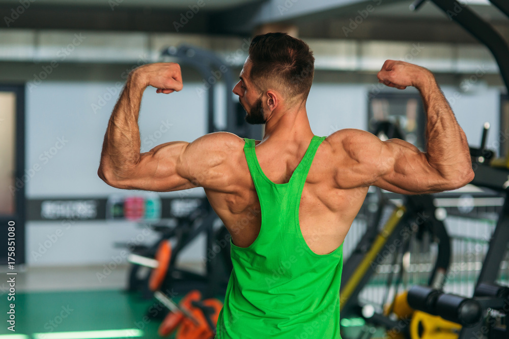 Young athlete posing with a torso for photography on a brick wall background. Bodybuilder, athlete with pumped muscles. Young athlete posing with a torso for photography on a brick wall background. Bodybuilder, athlete with pumped muscles.
