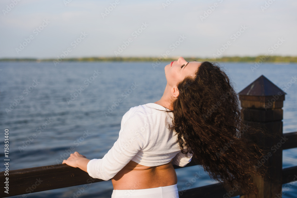 Young pregnant woman doing yoga outdoors. Pregnant yoga. Women doing different exercises. River on background. Concept of healthy lifestyle and relaxation, meditation.