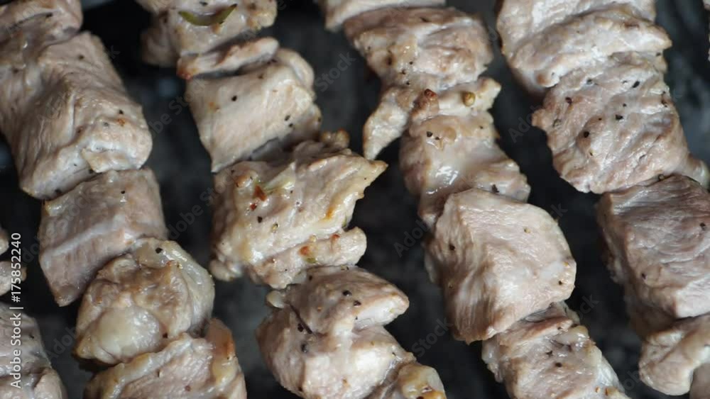 Fragrant kebab is roasted on skewers on the grill rotating Fragrant kebab is roasted on skewers on the grill rotating