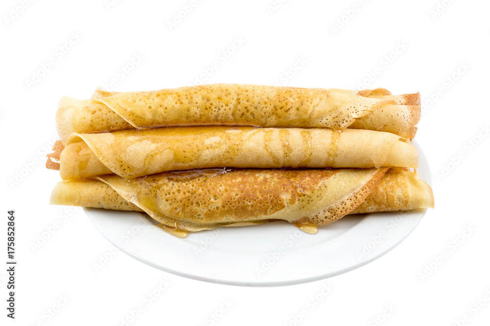 Rolled pancakes with honey on the plate. Isolated on white. Rolled pancakes with honey on the plate. Isolated on white.