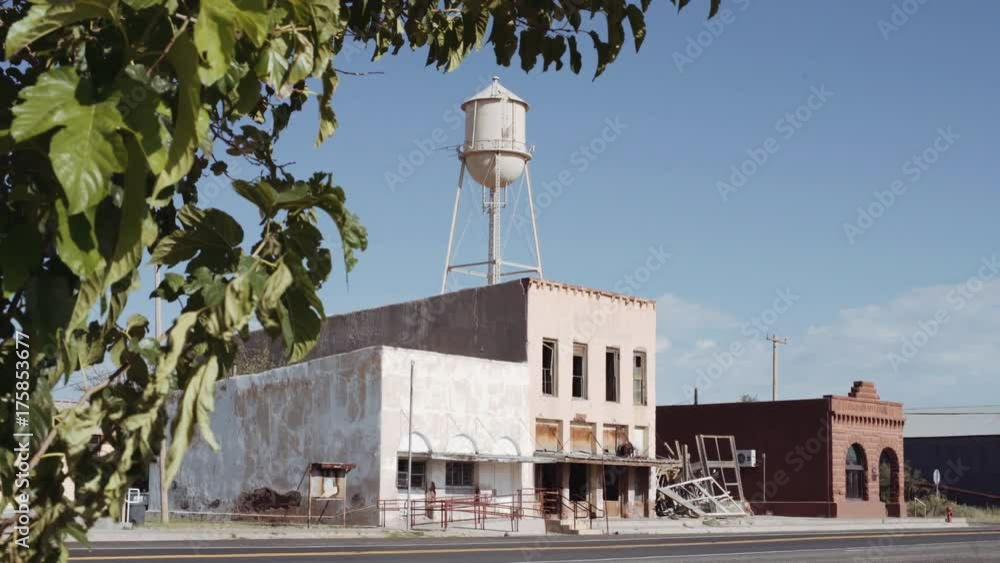 Abandoned Ghost Town with Water Tower. shot moves from a tree and ...