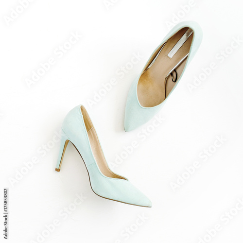 Beauty blog concept. Pale blue female shoes on white background. Flat lay, top view trendy fashion feminine background.
