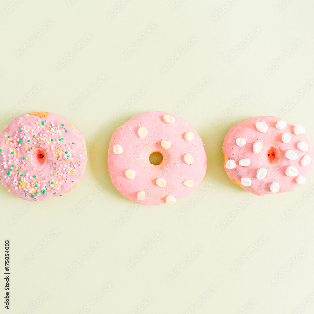 Pink donuts on green background. Flat lay, top view minimal pattern. Pink donuts on green background. Flat lay, top view minimal pattern.