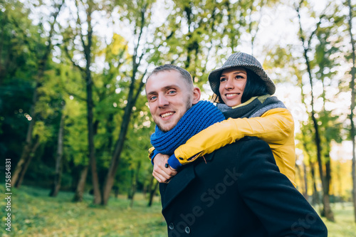 Happy Couple Having Fun in Autumn Park. Yellow Trees and Leaves. Laughing Man and Woman outdoor. Freedom Concept.