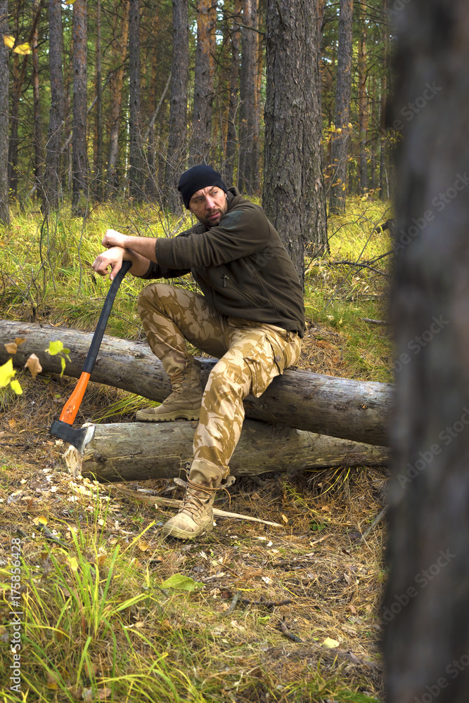 Lumberjack worker sitting in the forest .Resting after hard work. Lumberjack worker sitting in the forest .Resting after hard work.