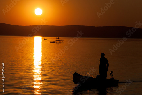 Beautiful sunset over Lake Balaton with anglers' silhouettes in Hungary