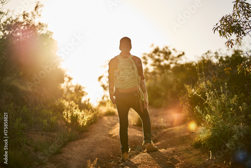 male millennial hiker trekking up trail in southern california during sunset © Joshua Resnick