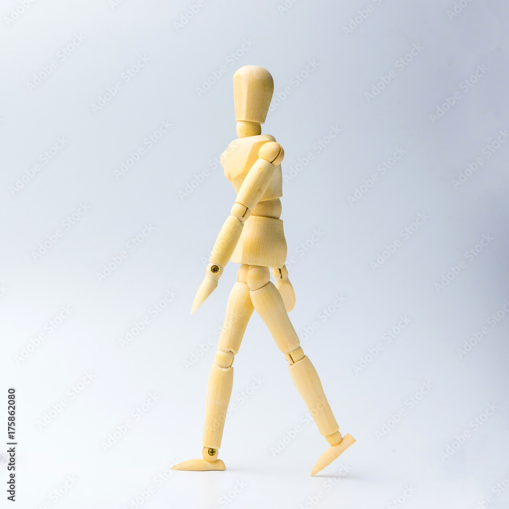 Wooden figure doll with walking action for business concept on white background Wooden figure doll with walking action for business concept on white background