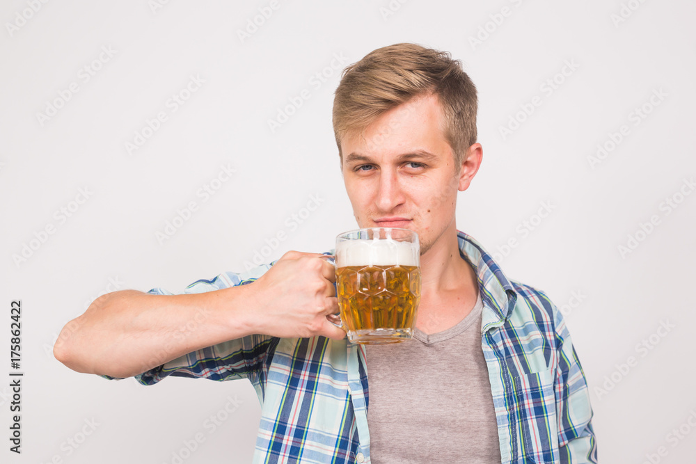 Man drinks beer. Handsome young guy drinking lager pint on white background Man drinks beer. Handsome young guy drinking lager pint on white background