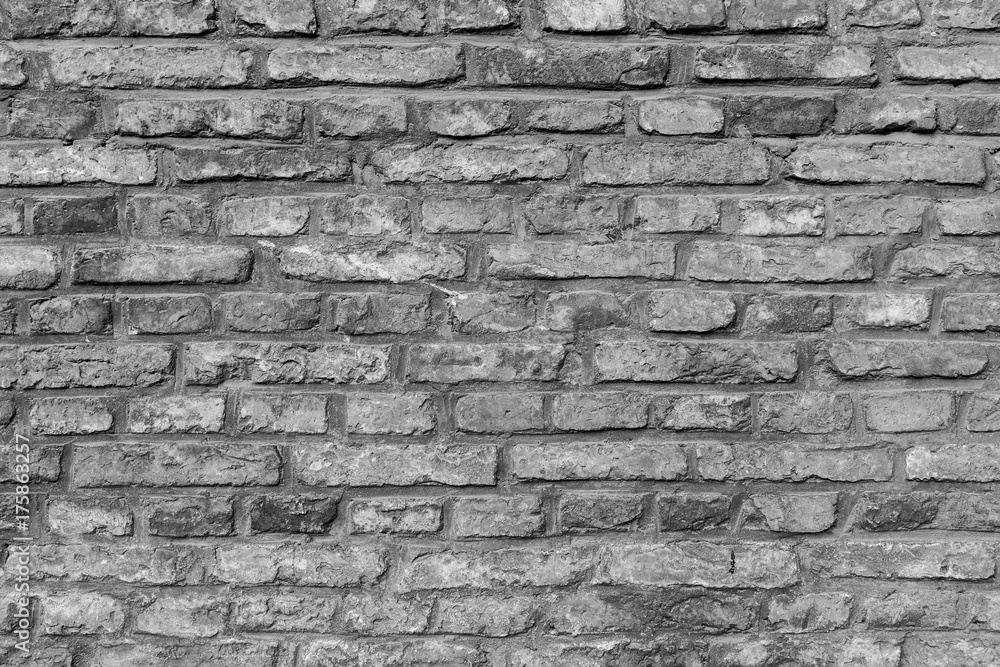 Fototapeta premium Close-up of an old and aged brick wall texture background in black and white.