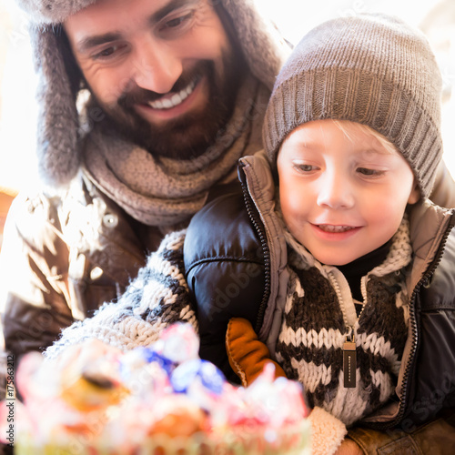 Dad and son taking sweets on traditional Christmas market photo