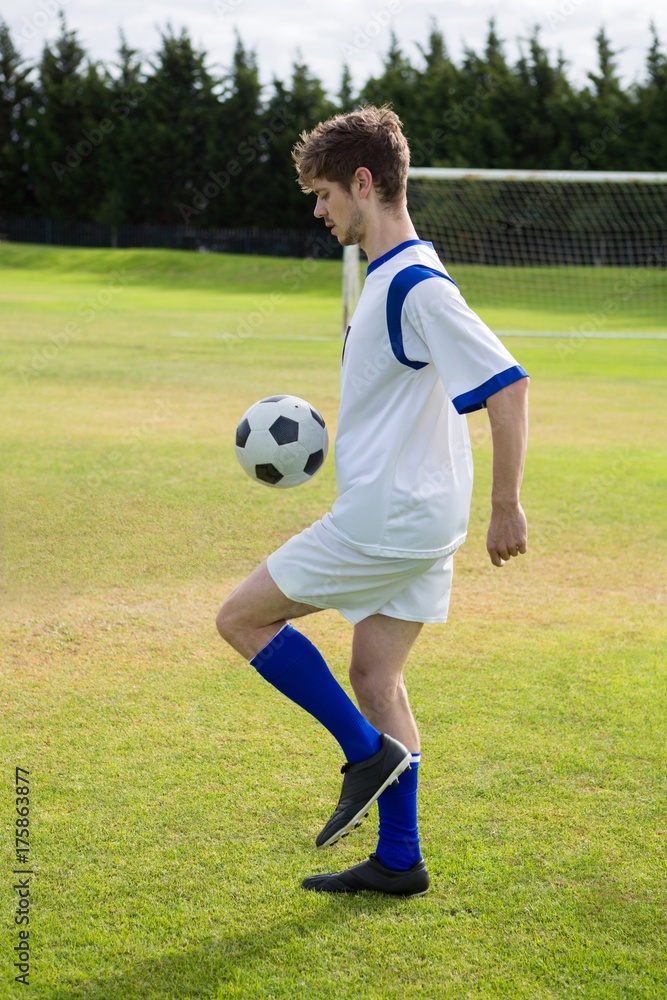 Side view of soccer player playing with ball Side view of soccer player playing with ball