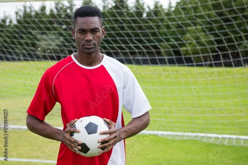 Portrait of serious confident male soccer player holding ball