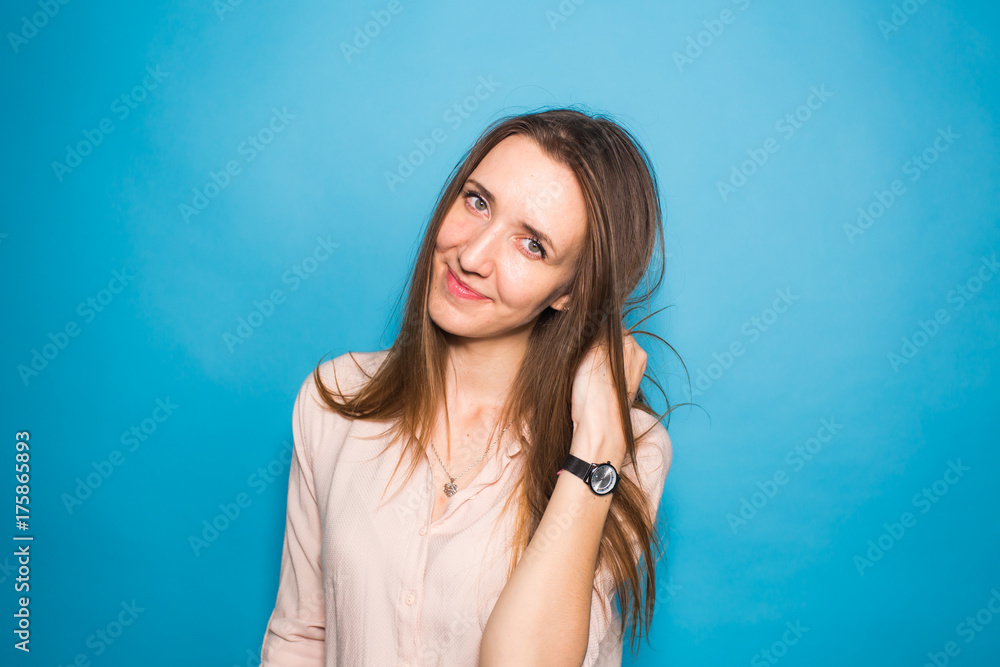 Beauty fashion portrait. Smiling young woman on blue wall background. Beauty fashion portrait. Smiling young woman on blue wall background.