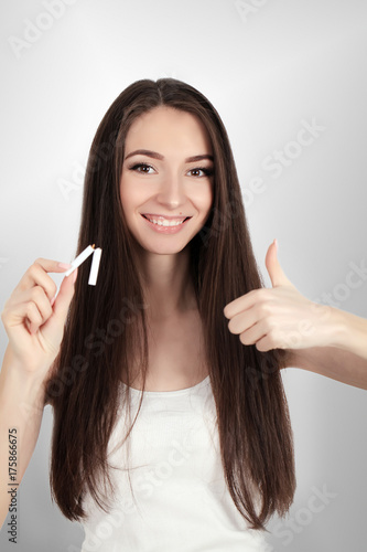 happy young beautiful woman holding a broken cigarette,quit smoking concept