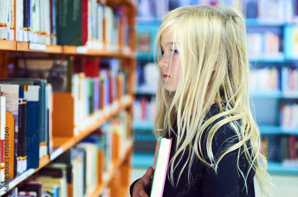 Child girl with book in public library Child girl with book in public library