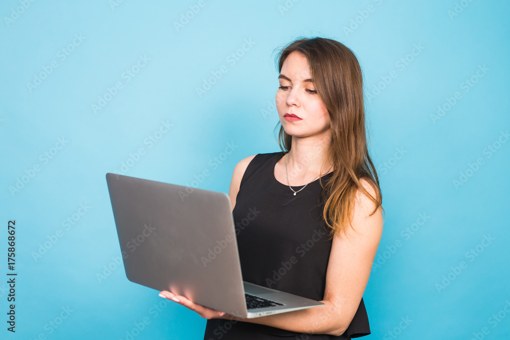 Smart beautiful young woman using laptop pc computer isolated on blue background Smart beautiful young woman using laptop pc computer isolated on blue background
