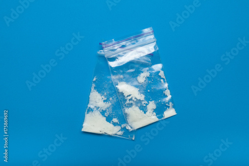 Cocaine close-up in plastic bags on a blue background.