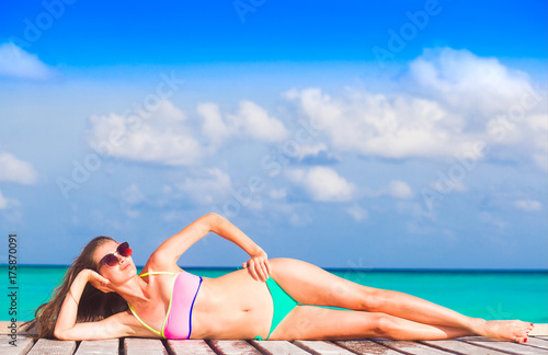 woman in bikini relaxing at white sand beach