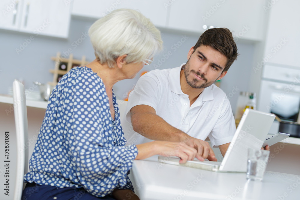 Fototapeta premium young man and his grandma working together on laptop