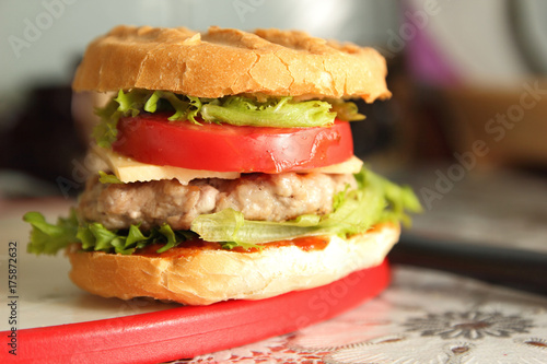 Cooking of burgers with veal  red tomatoes  lettuce  cheese and sauce in the home kitchen