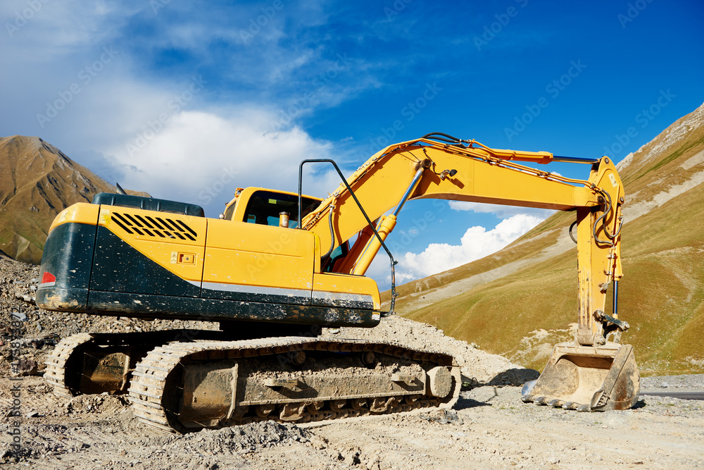 excavator loader machine at mountain road construction site