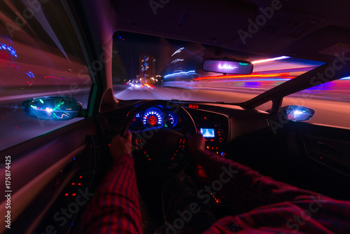 Night view of the street from the inside of the street car and other cars blurs the light. Night city lights in motion