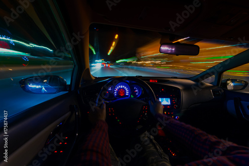 Night view of the street from the inside of the street car and other cars blurs the light. Night city lights in motion