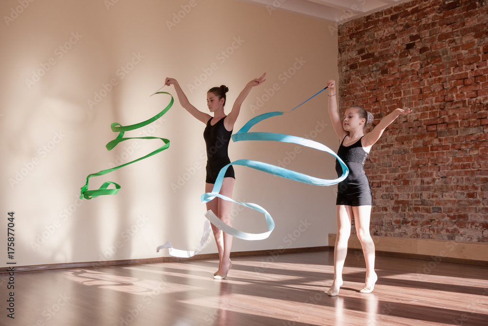 Young ballerinas in motion. Rhythmic gymnastics. Teenage sport, healthy  teen lifestyle. Pretty girls with flying ribbons, dance class background,  ballet concept Stock Photo | Adobe Stock